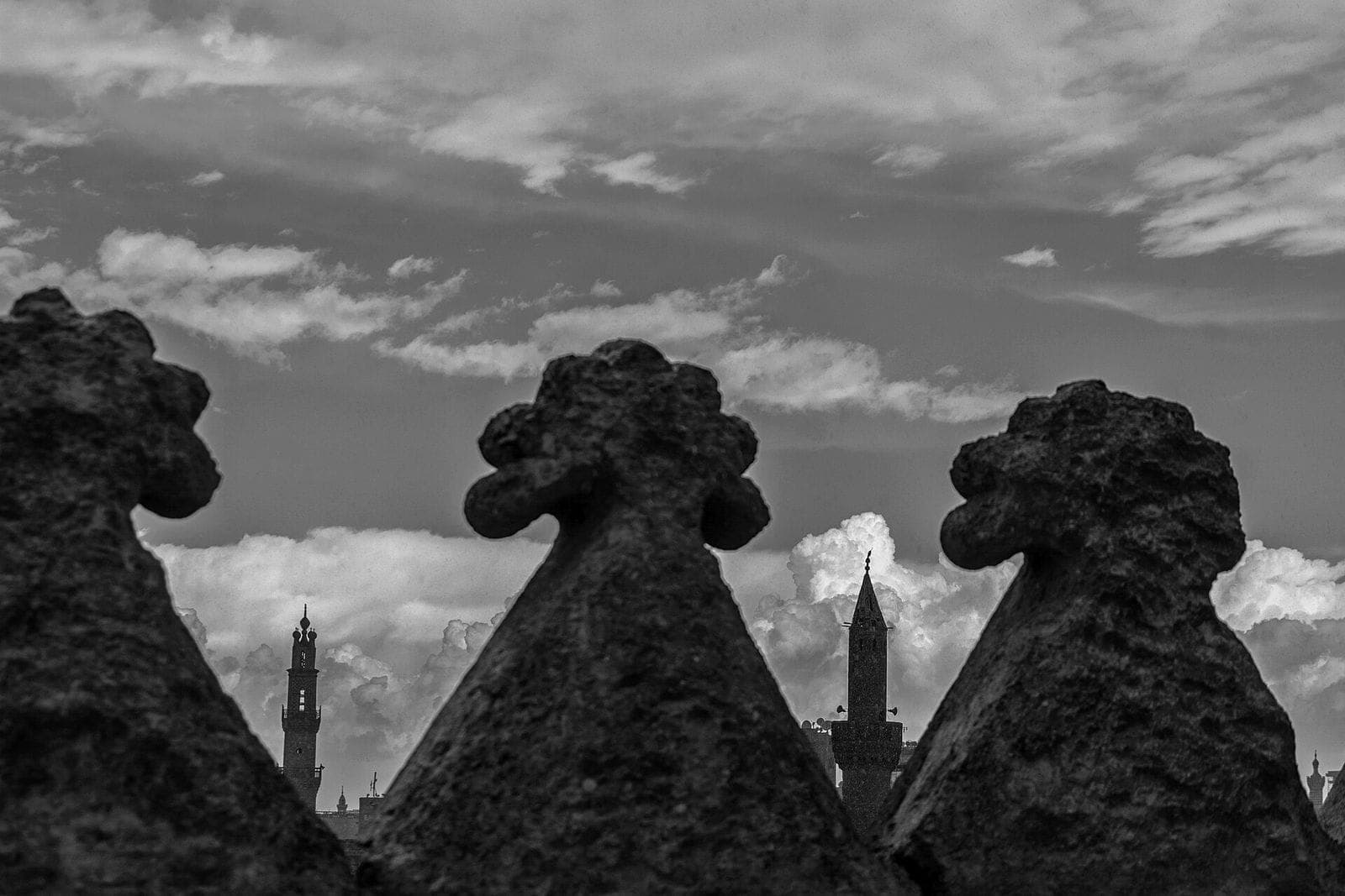 Cairo minarets seen between the stone crenellations of the Citadel wall